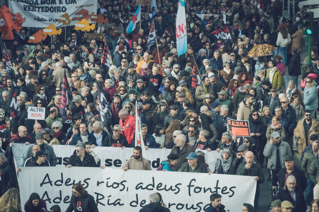 Fotografía da manifestación desde o alto, onde se ven moitas e moitos manifestantes. Ao comezo unha faixa onde se pode ler "Adeus ríos, adeus fontes. Adeus ría de Arousa"
