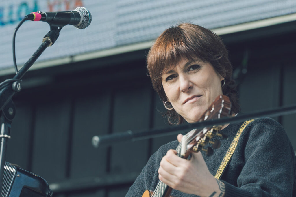 A contora Sés, tocando a guitarra no escenario durante o acto de peche da manifestacióni.